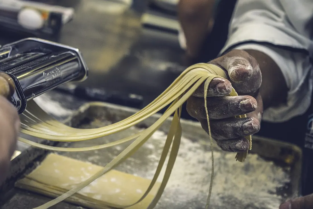 A chef cutting fresh pasta