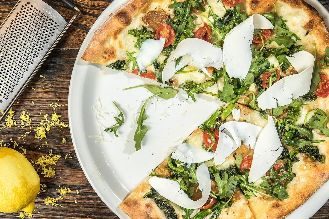 Pizza with rocket, tomato and shaved parmesan